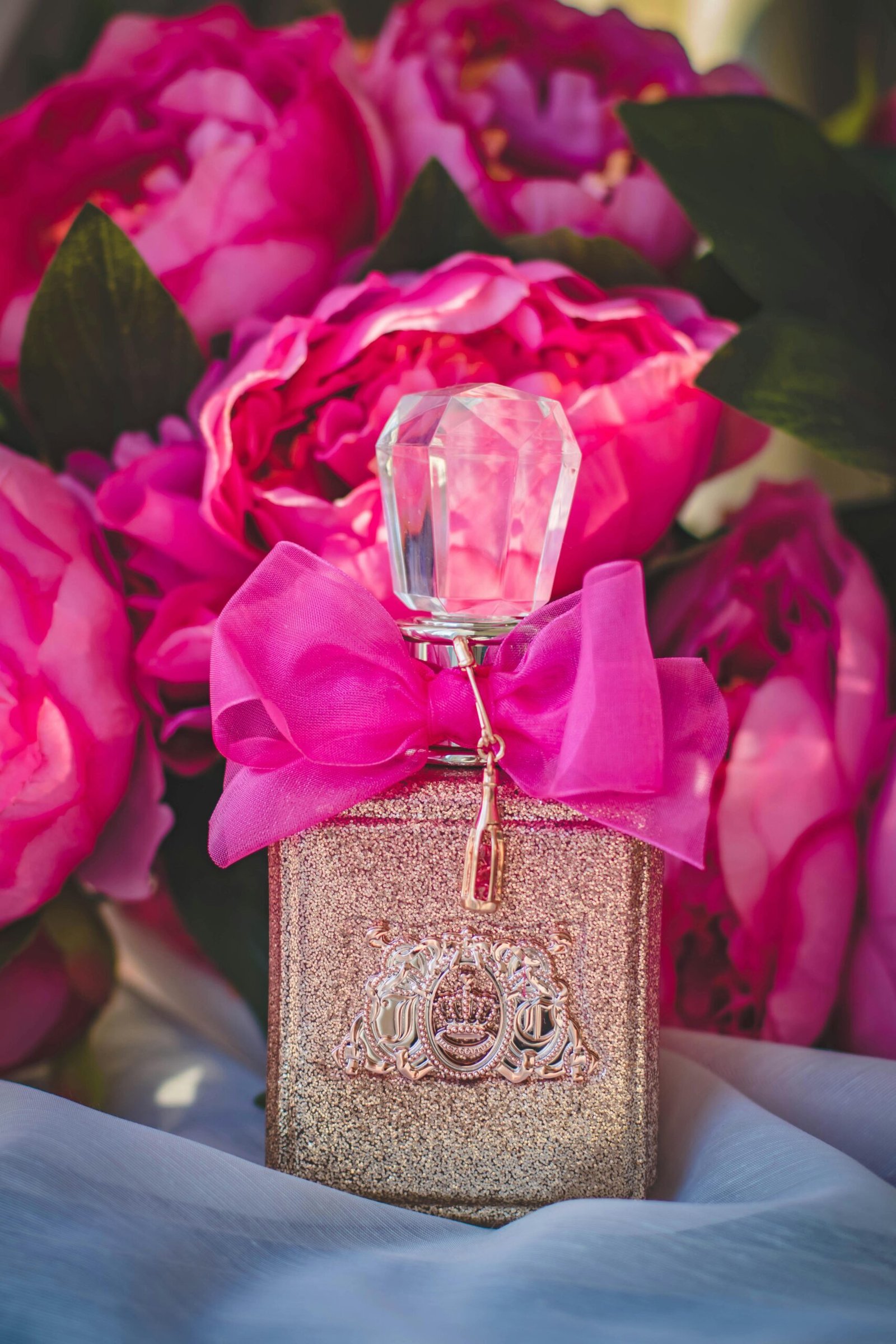 Luxurious perfume bottle surrounded by vibrant pink peonies, exuding elegance and romance.